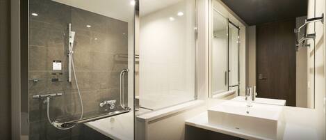 Un baño moderno con cabina de ducha de vidrio, bañera y tocador con espejo.