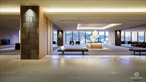 A spacious lobby with a reception desk, seating areas, and large windows offering a city view. - Daiwa Roynet Hotel Kagoshima Tenmonkan PREMIER  (Kagoshima)