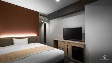 Ein Hotelzimmer mit Bett, Fernseher, Minibar und Spiegel.