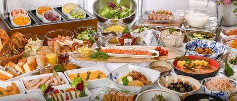 A buffet with various dishes including sushi, salads, and meats.