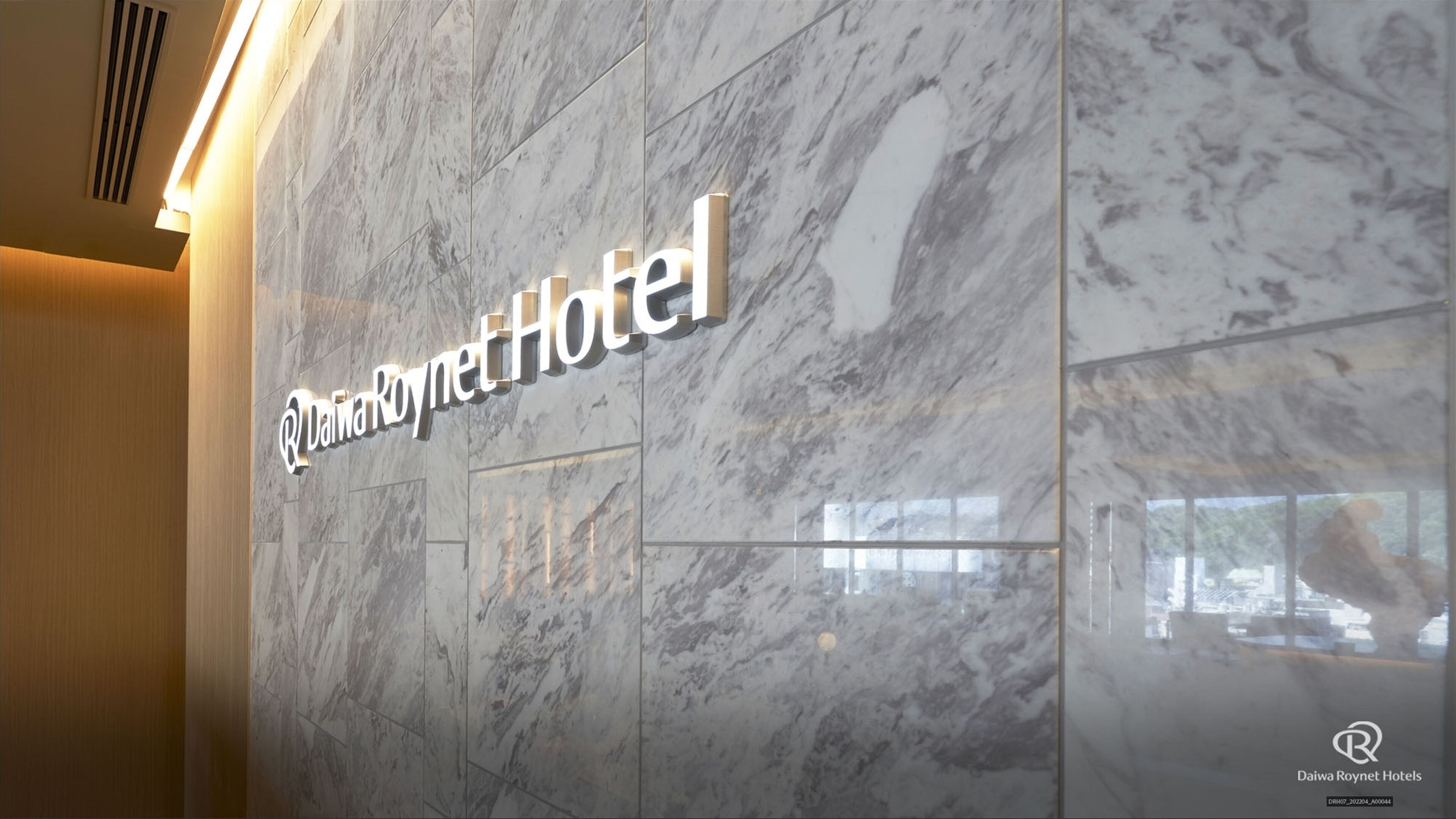 A marble wall with the Daiwa Roynet Hotel sign.