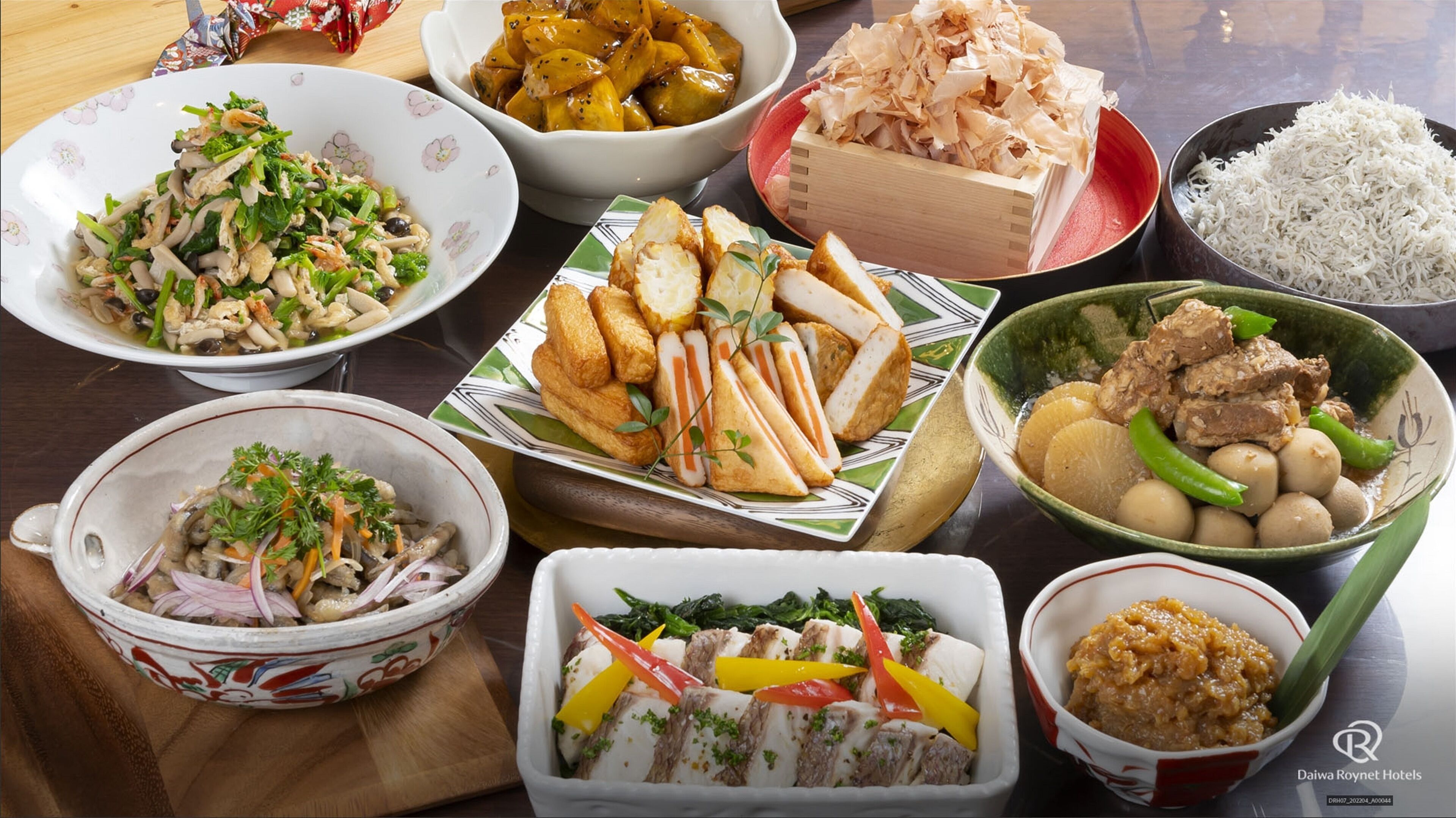 Una variedad de platos que incluyen arroz, verduras y carne, dispuestos sobre una mesa.