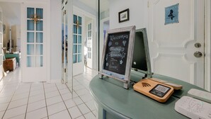 Un'area reception con una lavagna, un bancone in legno e un dispositivo per codice QR.