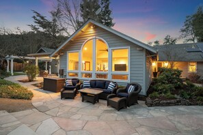 A house with a patio area featuring outdoor furniture and a stone pathway.