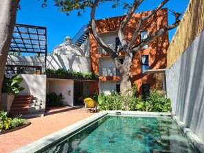 A pool area with a clear blue pool, a staircase, and a tree. - Rooms Huatulco (Santa María Huatulco)