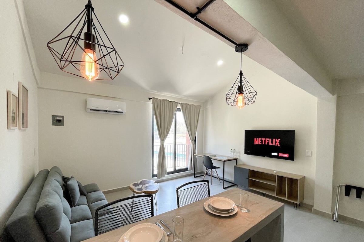 Un salon moderne avec un canapé, une table à manger et un téléviseur.