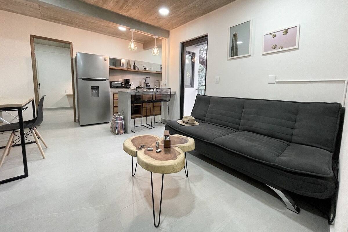 Un salon moderne avec un canapé, une table basse et un coin repas.
