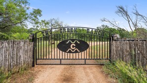 A gated entrance with a sign reading "TWO CREEK RANCH".