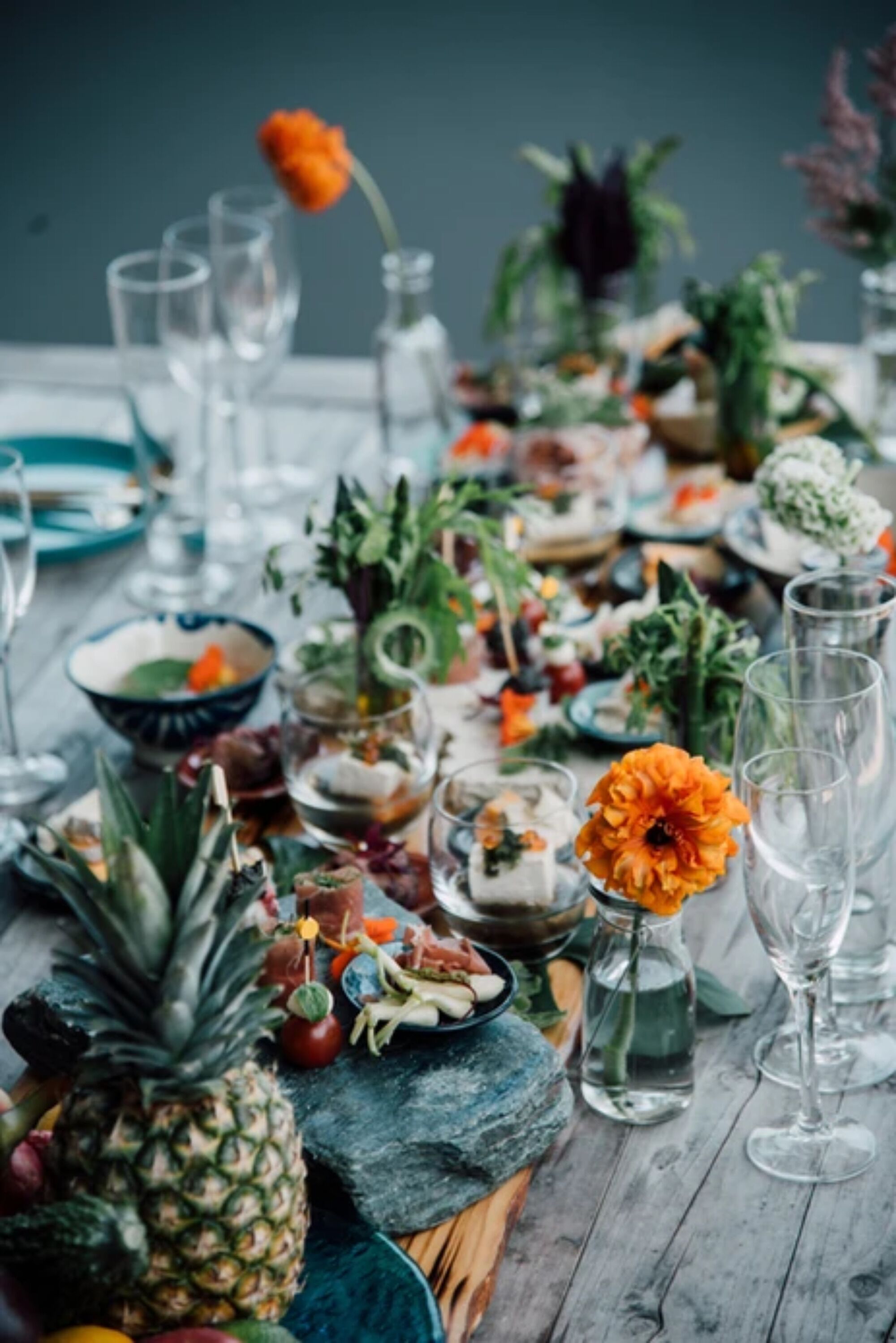 A table set with various dishes, drinks, and decorative elements.