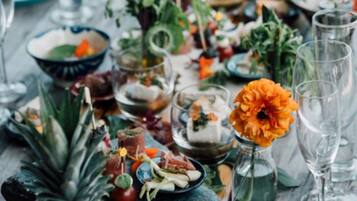 A table set with various dishes, drinks, and decorative elements.
