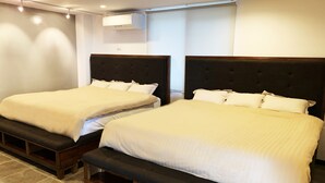 A hotel room with two beds, each with a dark headboard and white bedding. There is a bench between the beds, and an air conditioning unit mounted on the wall. - MARINX POOLVILLA NAKANDAKARI (Nanjo)