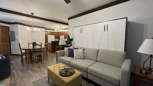 A modern living room with a sofa, ottoman, and dining area. - Best ski-in/ ski-out with A/C and fireplace! (Mont-Tremblant)