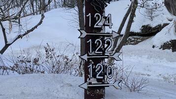 A wooden post with directional signs and a lantern.
