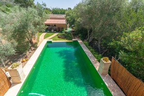 A rectangular swimming pool with clear water, surrounded by a wooden fence and stone pillars, with a house and lush greenery in the background. - CAS CONILL - Charming country house with private pool in the south of the island. Free wif (Llucmajor)