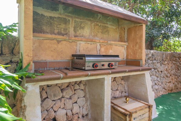 An outdoor grill with a stone base and a brick wall backdrop. - CAS CONILL - Charming country house with private pool in the south of the island. Free wif (Llucmajor)