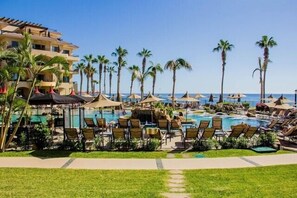 Et resort med flere swimmingpools, palmer og liggestole.