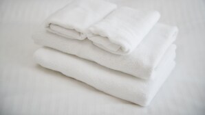 A stack of white towels on a white surface.