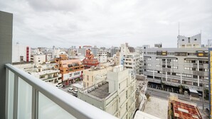 A cityscape with various buildings, including a prominent red-roofed structure and a modern white building with balconies.