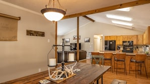 Una cocina acogedora con armarios de madera, una isla central y una lámpara colgante.
