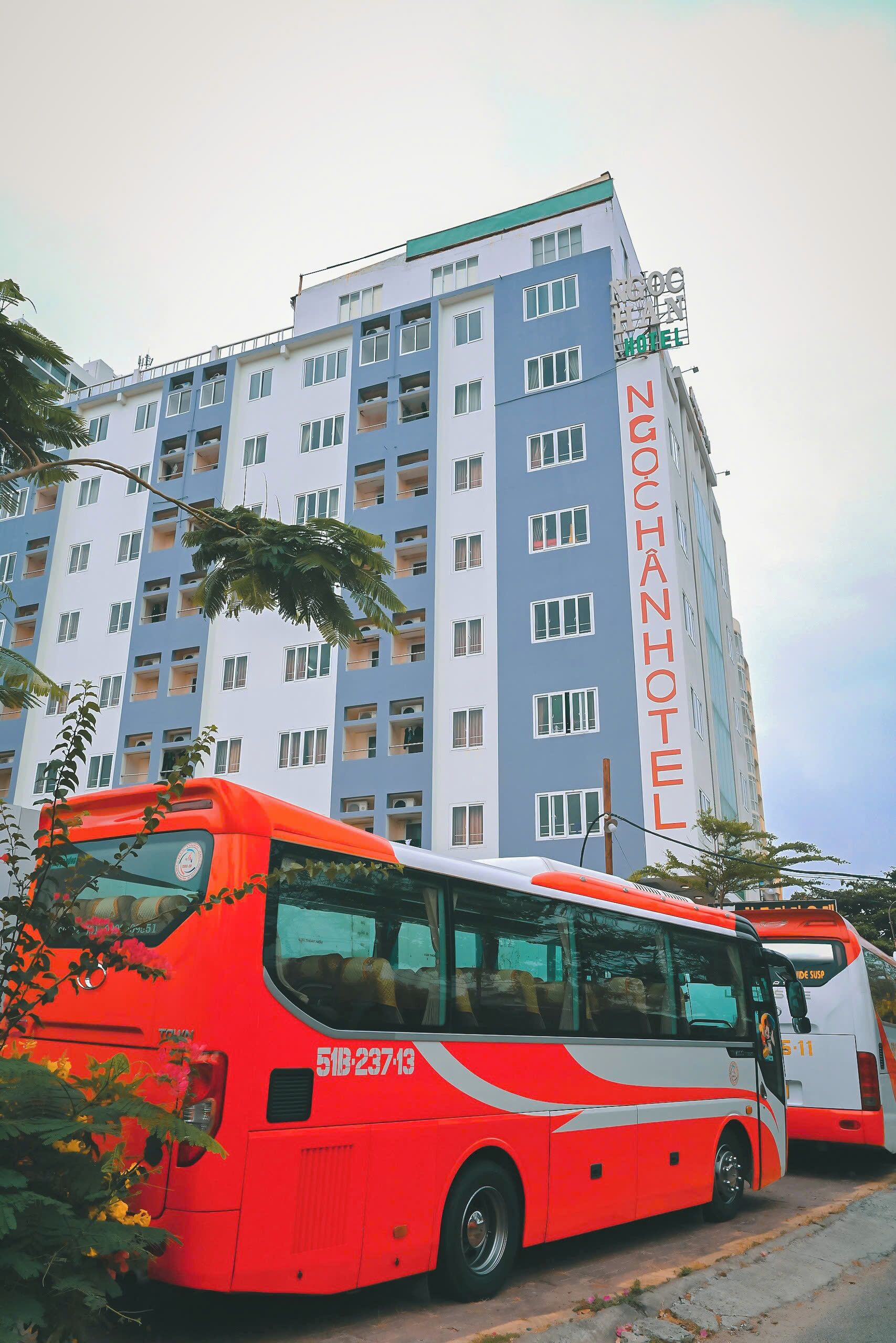 A multi-story building with a prominent sign reading "NGOCHANHOTEL".