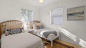 A bedroom with two beds, a ceiling fan, and a window with blinds. - "Sunflower Cottage Apt" 2/1 (West Palm Beach)