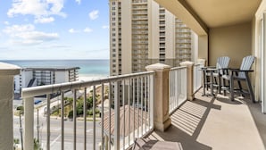A balcony with a view of the ocean and high-rise buildings.