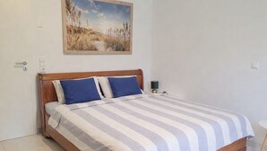 A bedroom with a bed, a nightstand, and a painting on the wall. - Vacation home Südwind - Maisonette apartment no. 2 (Rhauderfehn)