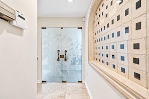 A hallway with a glass door featuring a decorative design, a wall-mounted air conditioning unit, and a tiled floor. - Coronado Cays Beachfront with Private Pool & Spa (Coronado)