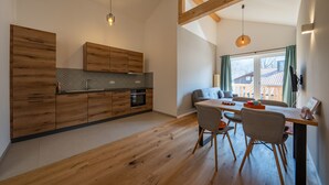 Eine moderne Küche mit Holzausstattung, einem Einbauofen und Pendelleuchten.