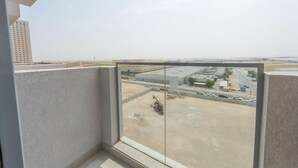 Vista desde un balcón sobre un estacionamiento, con un edificio al fondo.