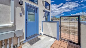 A building with a blue door and windows, a gated entrance, and a clear sky. - Salida Hideaway- New Studio Condo (Salida)