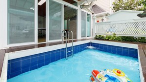 A swimming pool with a ladder, a small inflatable toy, and a white fence. - Daebudo Fullhouse Pension (Ansan)