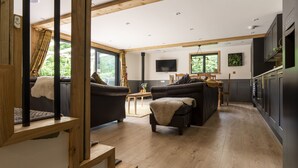 Ein modernes Wohnzimmer mit einer Couch, einem kleinen Tisch und einem Fernseher.