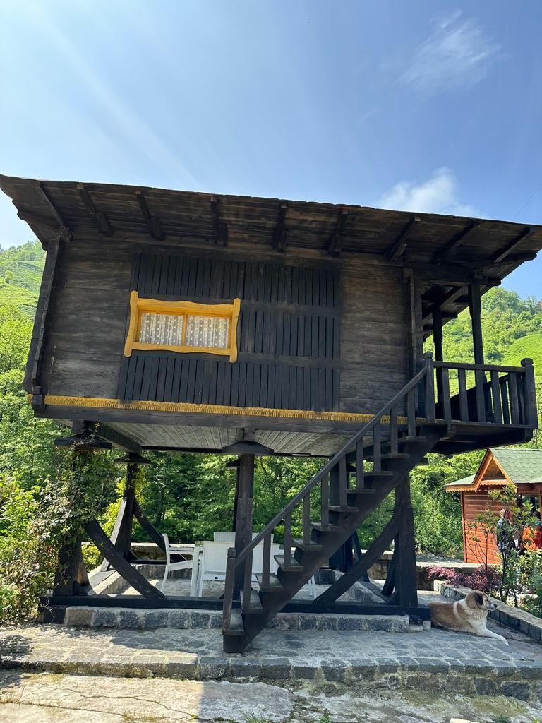 A wooden structure with a balcony, stairs, and a window.
