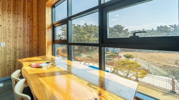 Una mesa de madera con vistas a una obra en construcción a través de amplios ventanales.