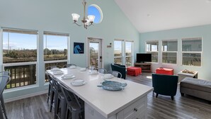 A spacious living area with a large island, multiple seating options, and a television. - Steps from the Beach!  (Crystal Beach)