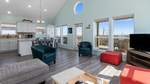 A spacious living area with a kitchen, a dining area, and a balcony with a view. - Steps from the Beach!  (Crystal Beach)