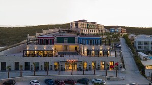 Un hôtel doté d’une façade en pierre, de nombreux balcons et d’un espace piscine.