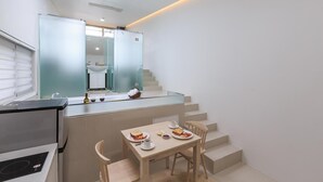 A compact kitchen with a dining area, a small refrigerator, and a window. - Ganghwa Nolang Pension (Incheon)