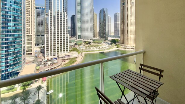 A balcony with a view of modern high-rise buildings and a body of water. - LKV - 1bed with 2 balconies in JLT (Dubai)