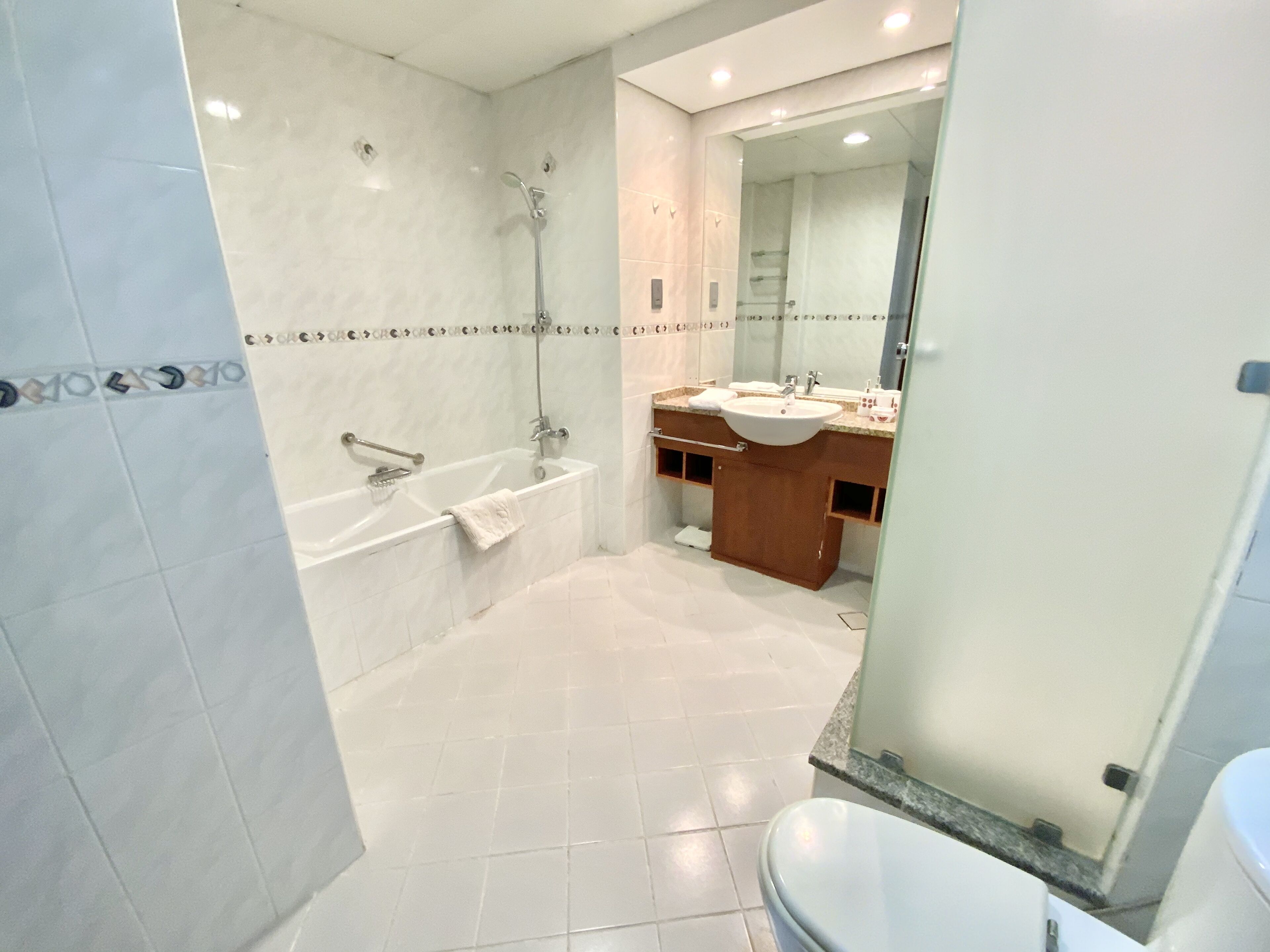 A modern bathroom with a bathtub, shower, and sink.