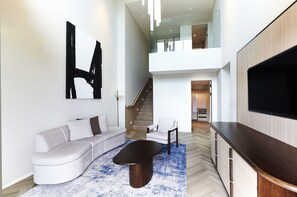 A modern living room with a sectional sofa, a coffee table, and a flat-screen TV.