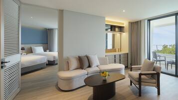A modern hotel room with a bed, a sofa, a coffee table, and a balcony with a view.