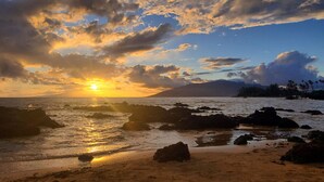 A beach with rocky formations and a sunset. - Maui Paradise: Steps to Sand-Blg#1. Partial Ocean View, AC's, Wifi, 1st Floor (Kihei)