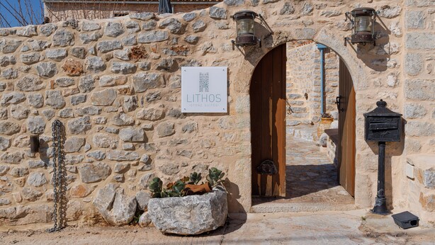 A stone building with a sign reading "LITHOS Stone Suites." - Lithos Stone Suites (East Mani)