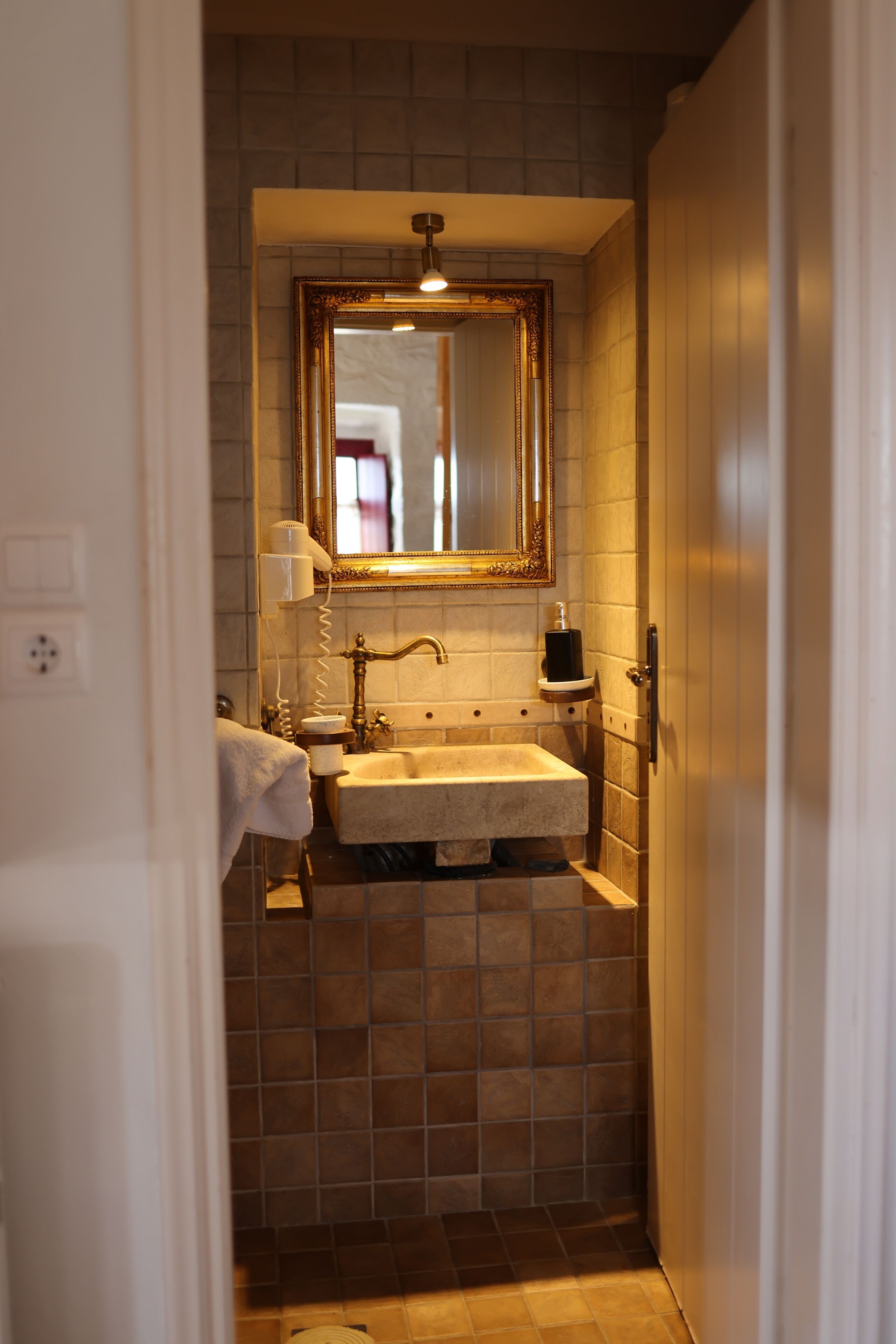 A bathroom with a large mirror, a sink, and a towel rack.