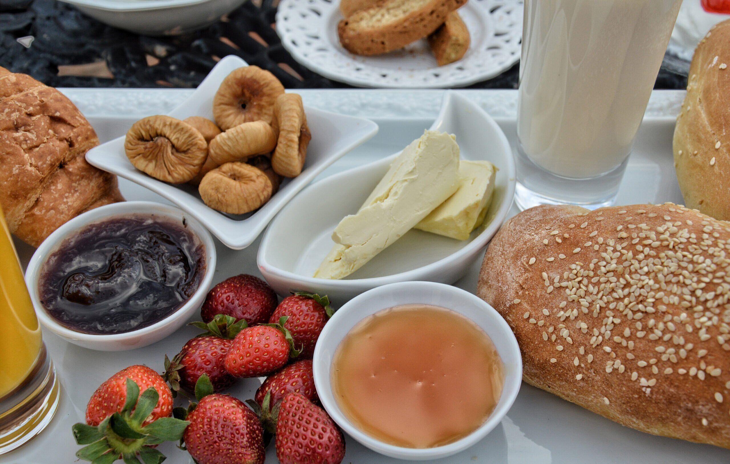 A table with various food items including pastries, strawberries, and bowls of different spreads.