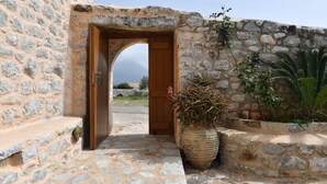 Un edificio de piedra con una puerta de madera que da a un área empedrada.