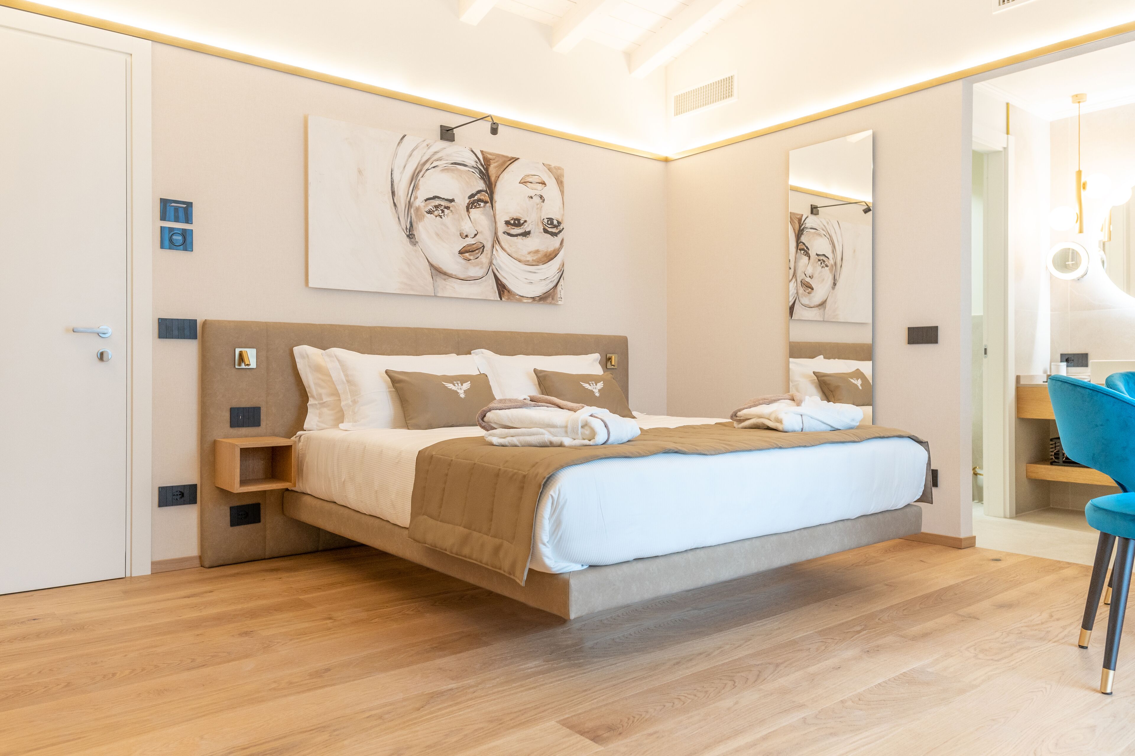 Un dormitorio moderno con una cama grande, suelo de madera y obras de arte en las paredes.
