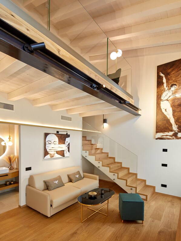 Una sala de estar moderna con un sofá, una mesa de centro y una escalera que lleva a un nivel superior.